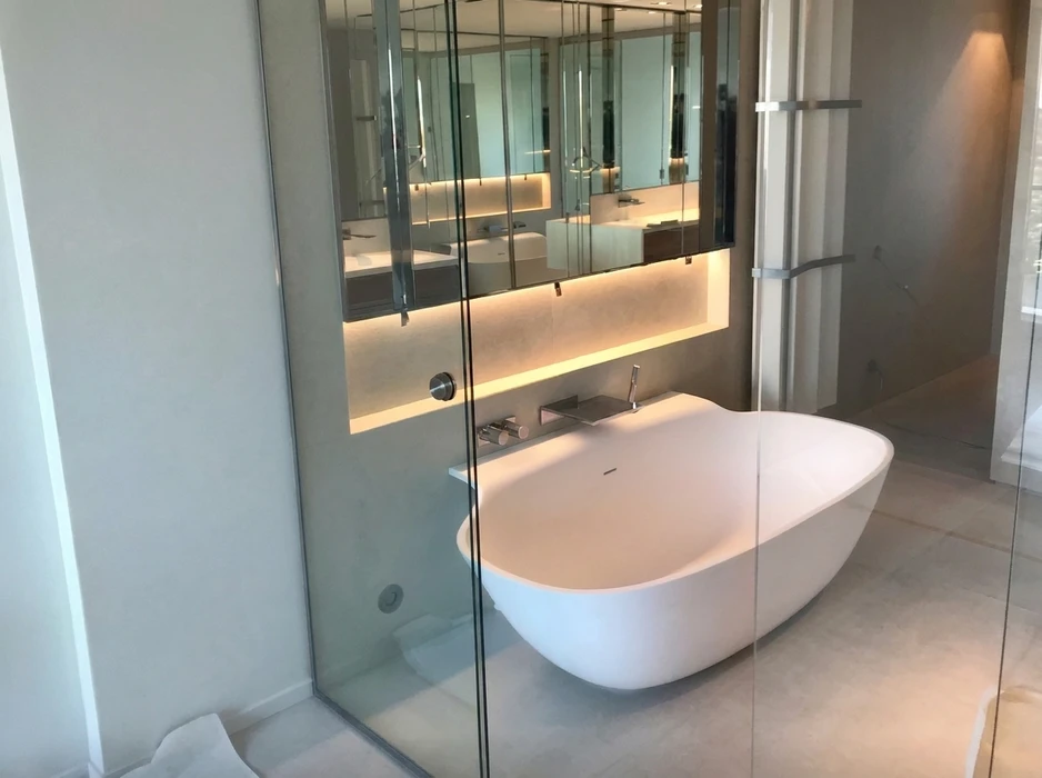 Salle de bain luxueuse avec baignoire îlot autoportante en solid surface blanc mat, robinetterie murale chromée encastrée