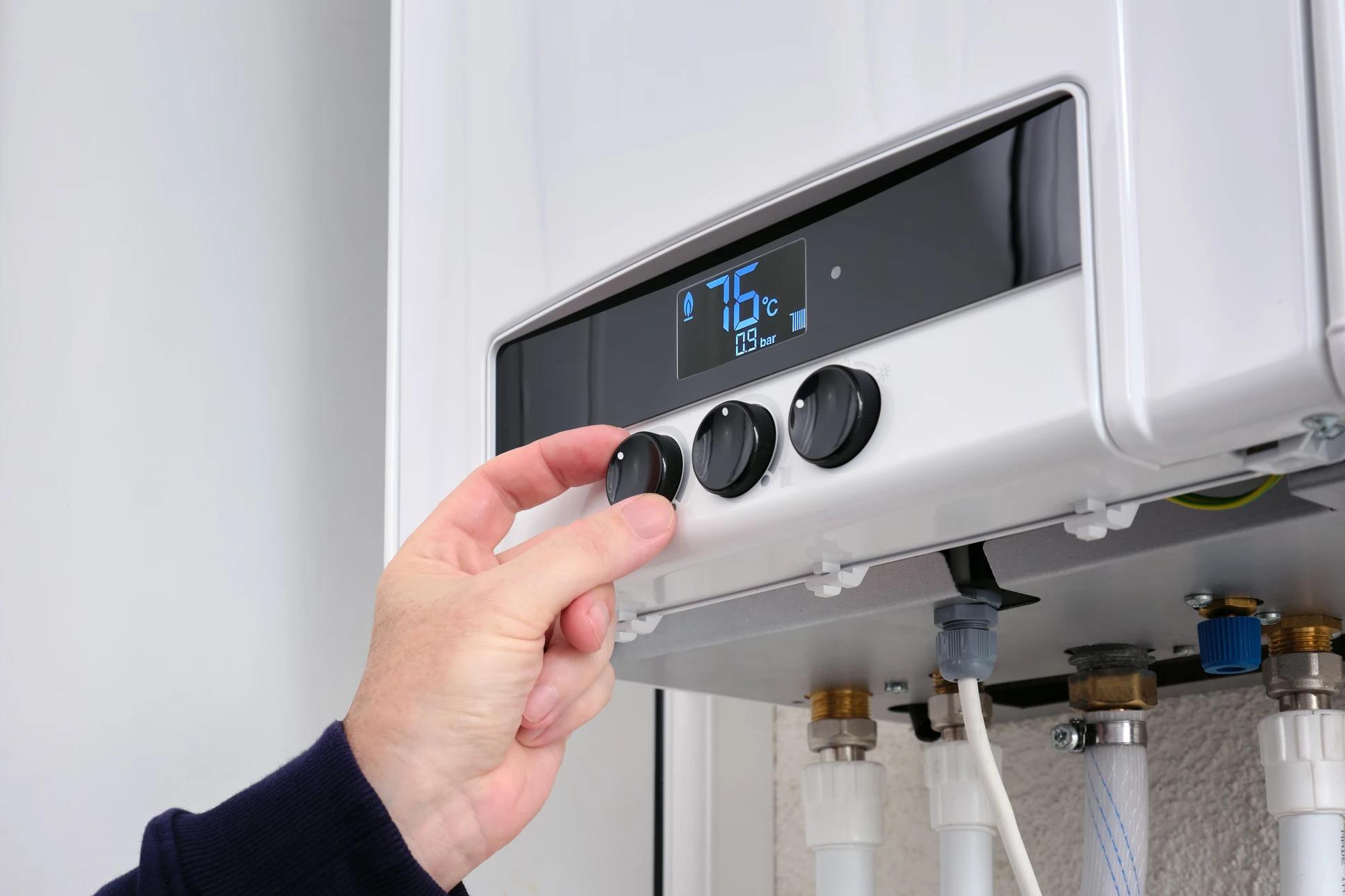 Intérieur d'un local technique avec chaudière murale blanche à gaz condensation
