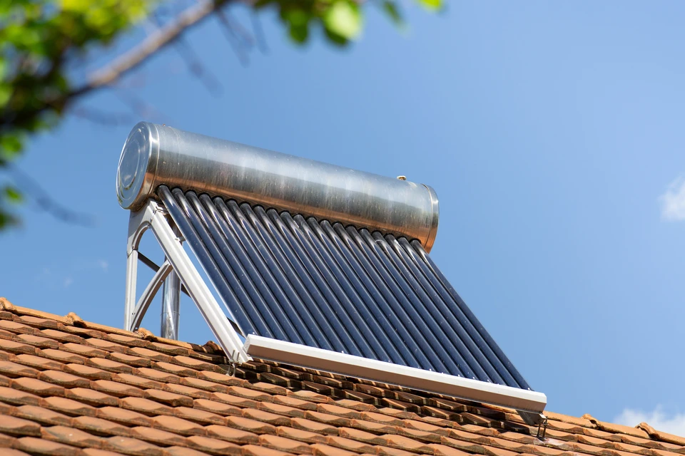 Scène extérieure sur toiture en tuiles canal terre cuite avec installation de chauffe-eau solaire thermique